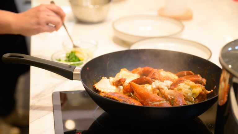 Tourists cooking Singapore's famed local dish - Chilli Crab